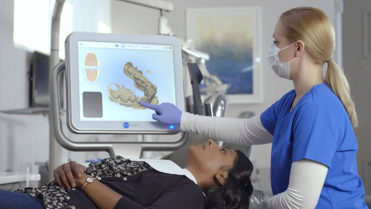 Dentist showing patient a 3d model of teeth made with the iTero scanner at best cosmetic dentist in San Mateo