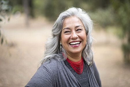 Beautiful Mexican Woman with White Hair smiling after cosmetic dentist procedure in san mateo